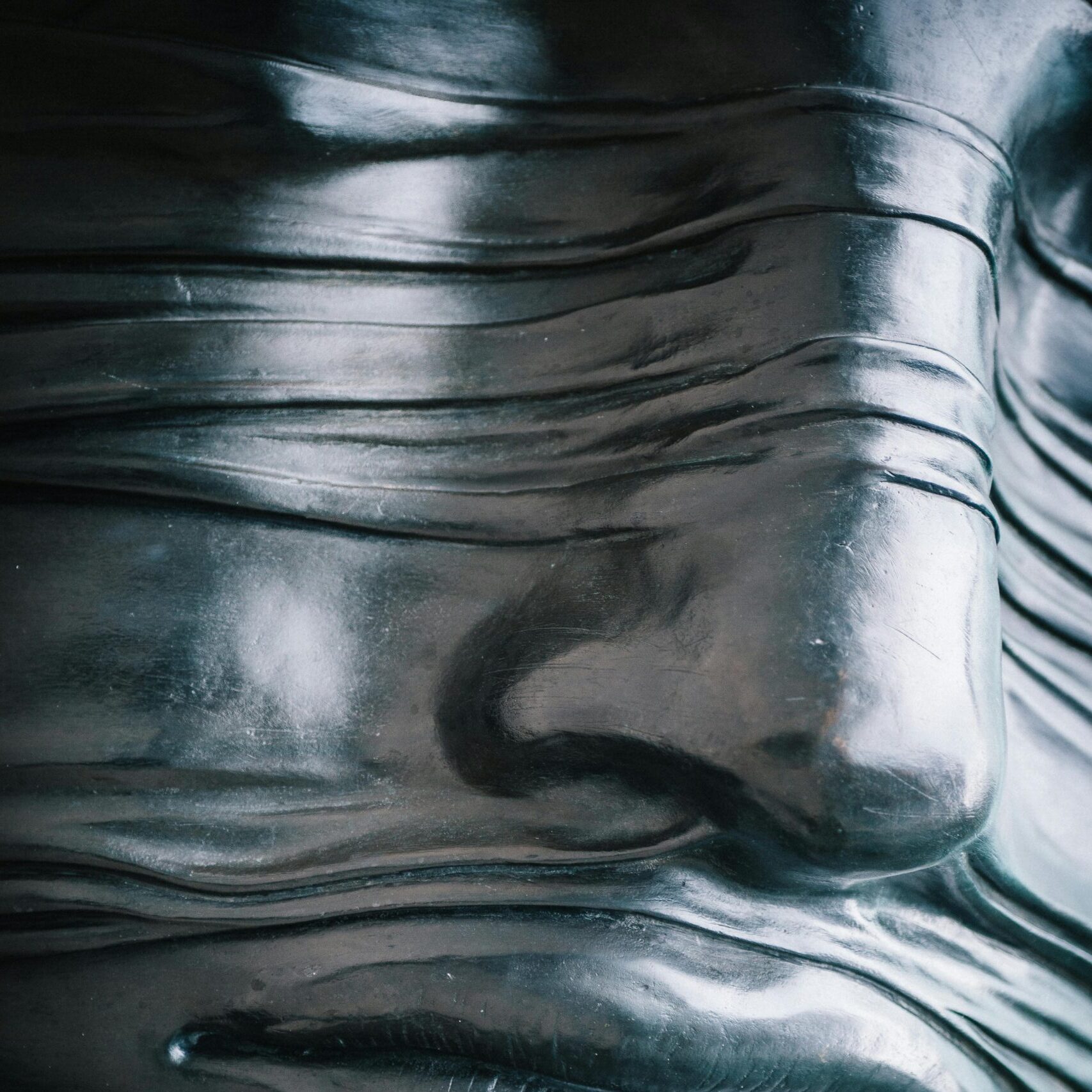 Close-up view of a textured metallic sculpture emphasizing patterns and reflections.